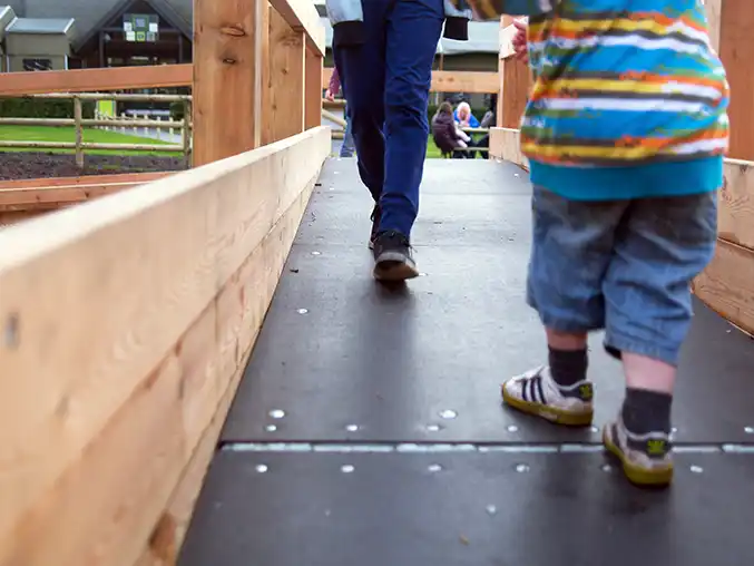 Toddlers standing on a wheelchair seesaw